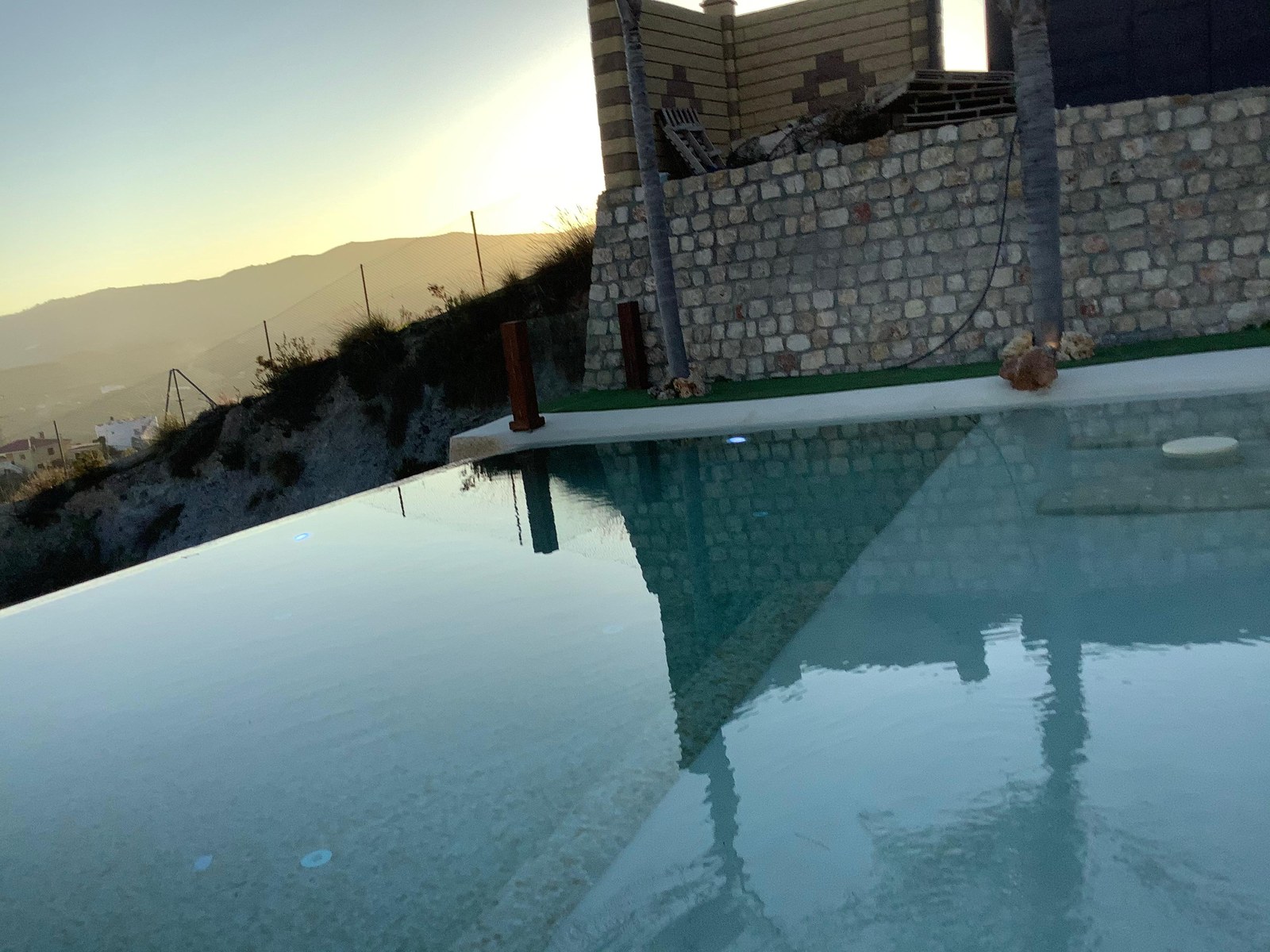 Piscina desbordante al atardecer
