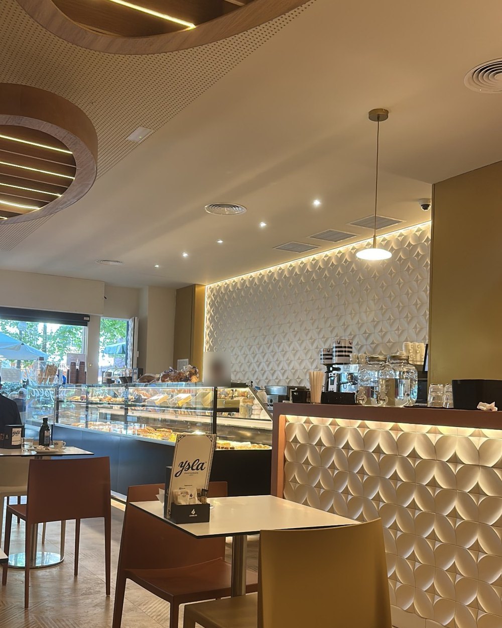 Cafetería Ysla con techo de listones de madera, luz LED y barra de azulejo en relieve, proyecto de Kosta Kosta Interiorismo