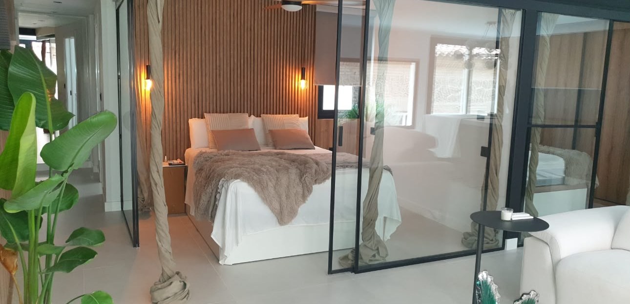 Dormitorio separado del salón con mampara de vidrio y perfil negro