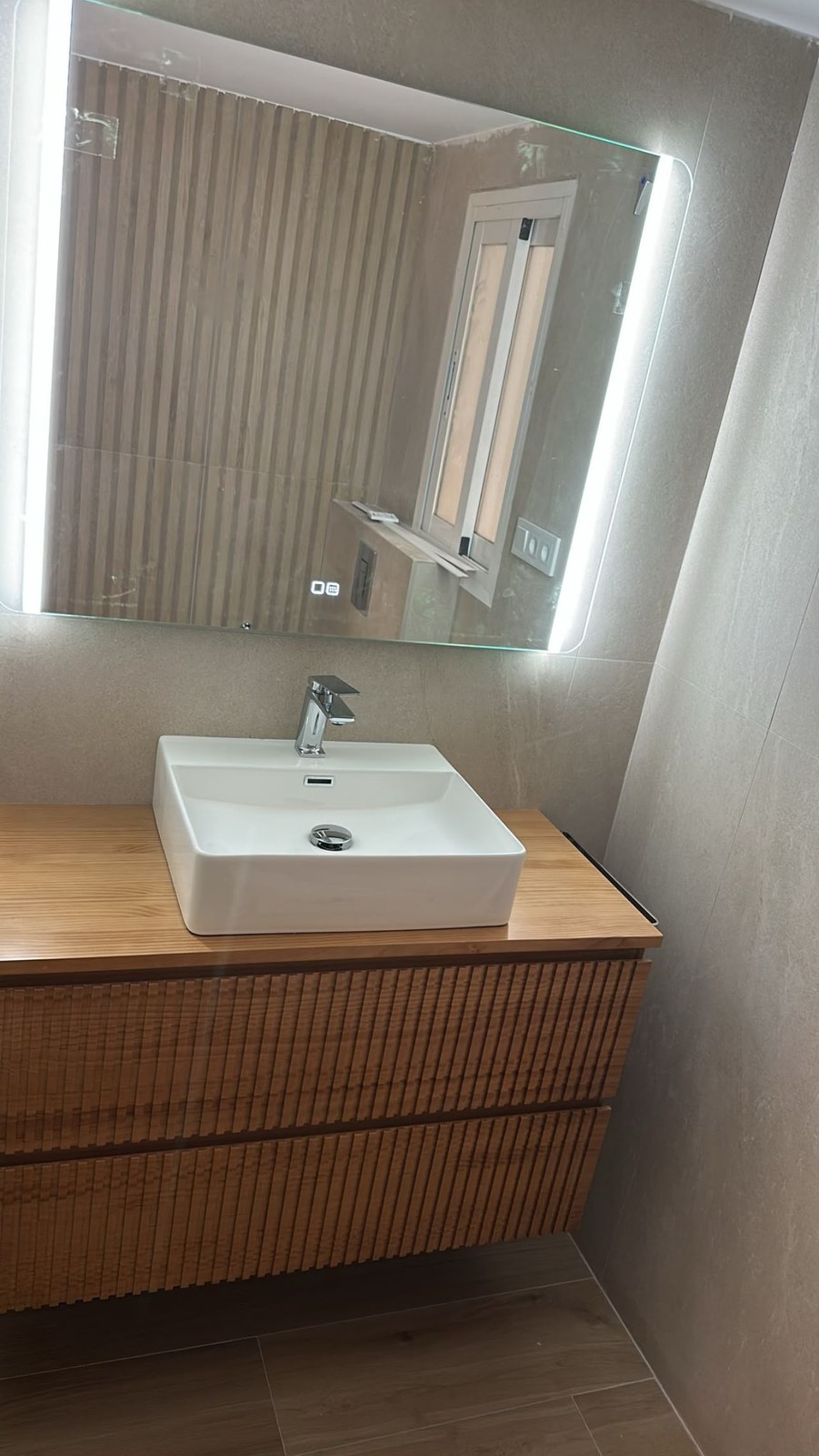 Mueble de baño de madera acanalada con espejo retroiluminado