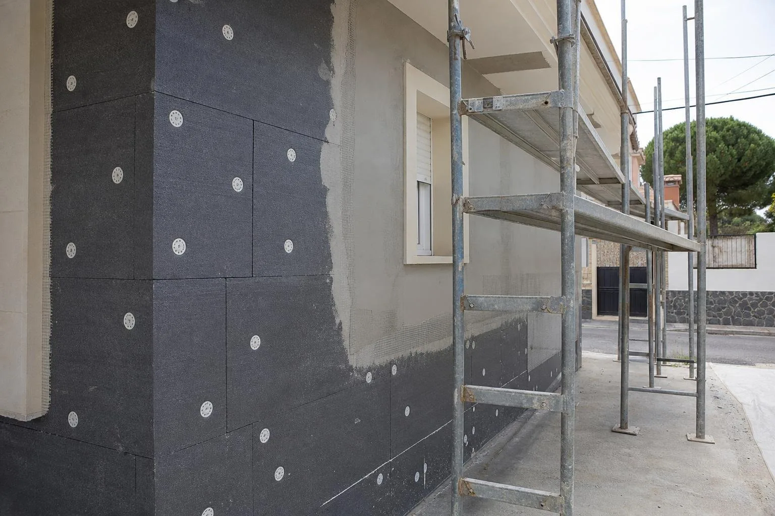 Paneles de aislamiento exterior fijados en una fachada con malla