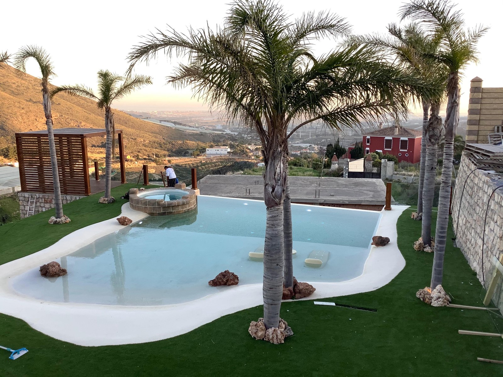 Jardín con palmeras y piscina de playa terminada