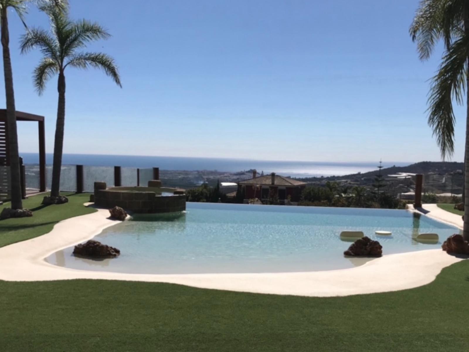 Piscina de arena con playa y vistas al mar